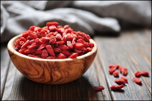 wooden-bowl-with-goji-berries-on-the-table-closeup